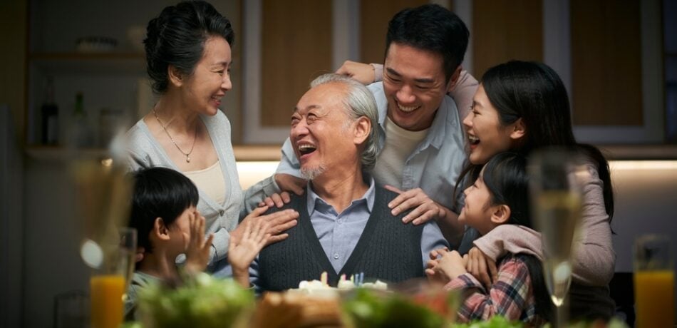 A happy family celebrates a grandfather's birthday at home.