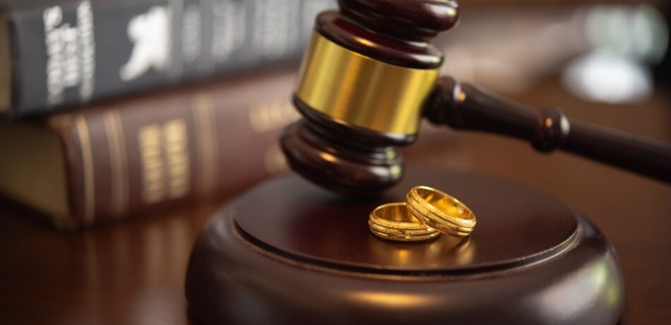 A gavel next to wedding rings.