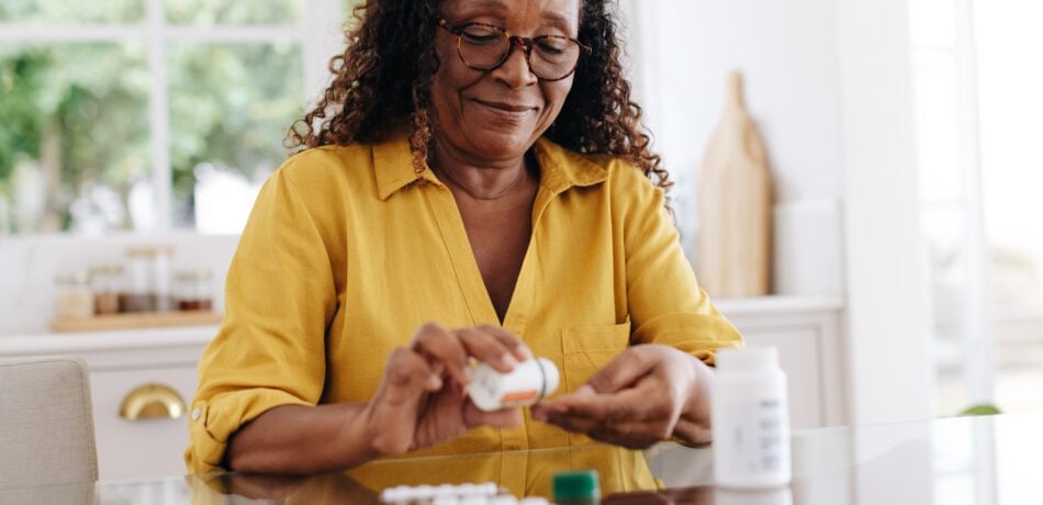 Senior woman taking prescription medication at home