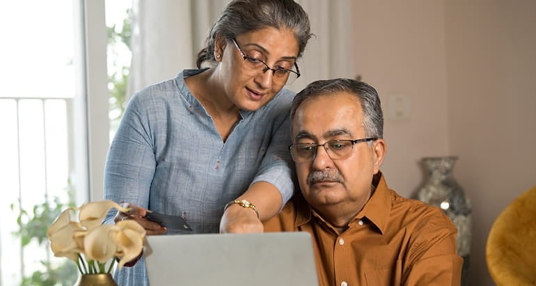A man and woman explore their Medicare options on a laptop.