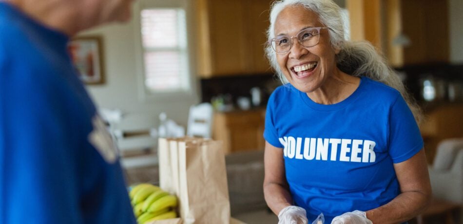 Cheerful mature adult woman volunteering for community service center.