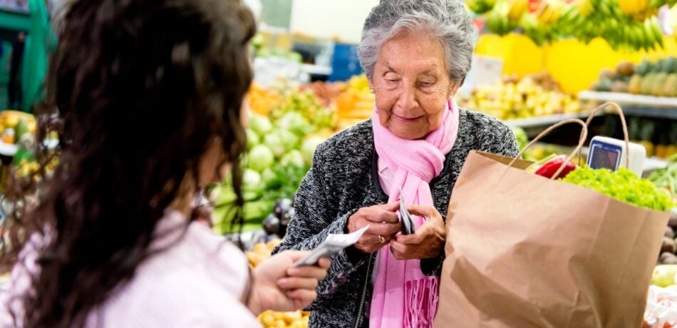 Woman customer paying at the supermarket after buying groceries.